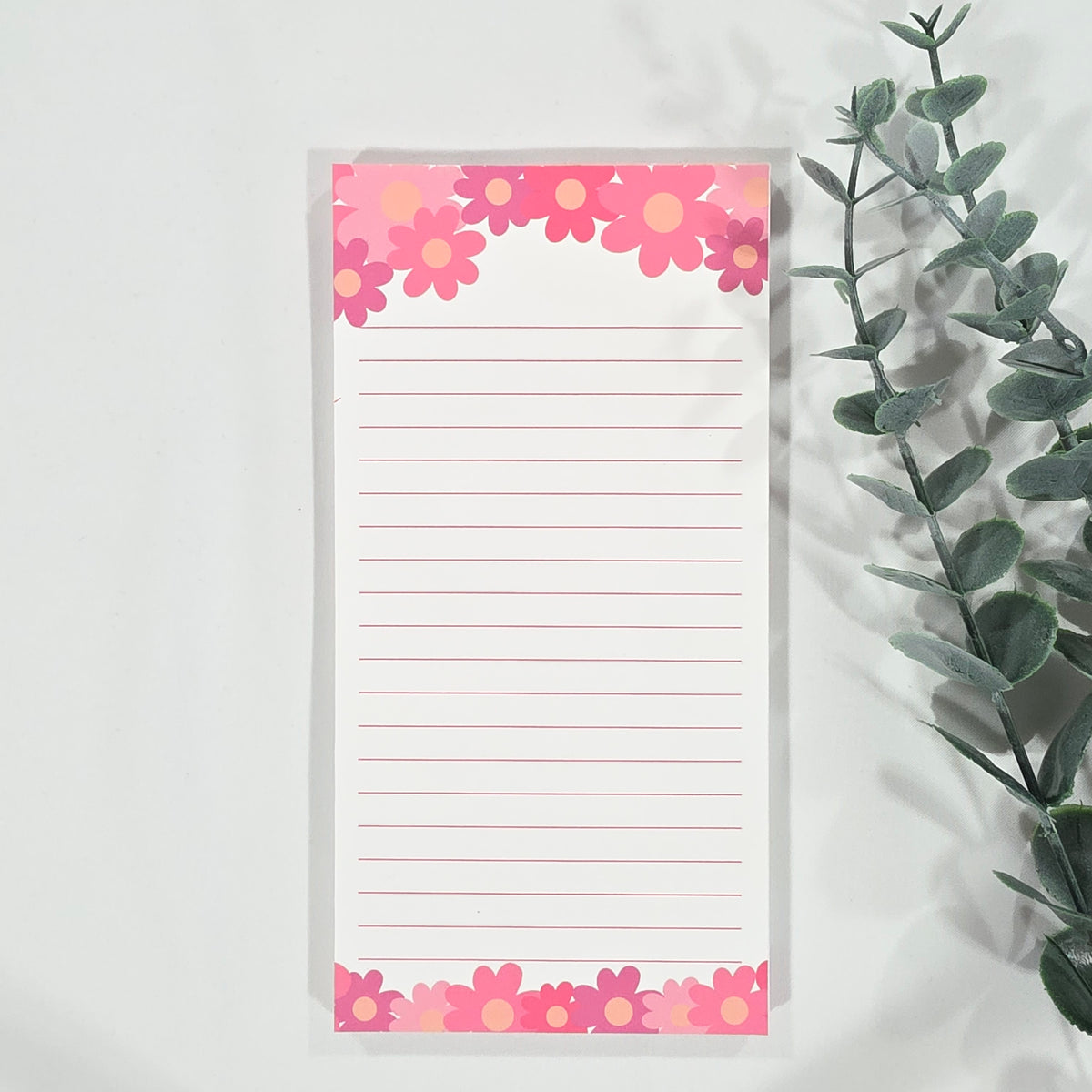 Notepad with floral border on a light background