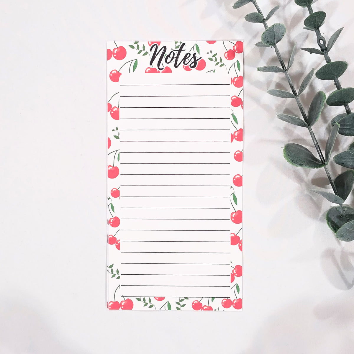 Notepad with cherry design and 'Notes' text on a white background