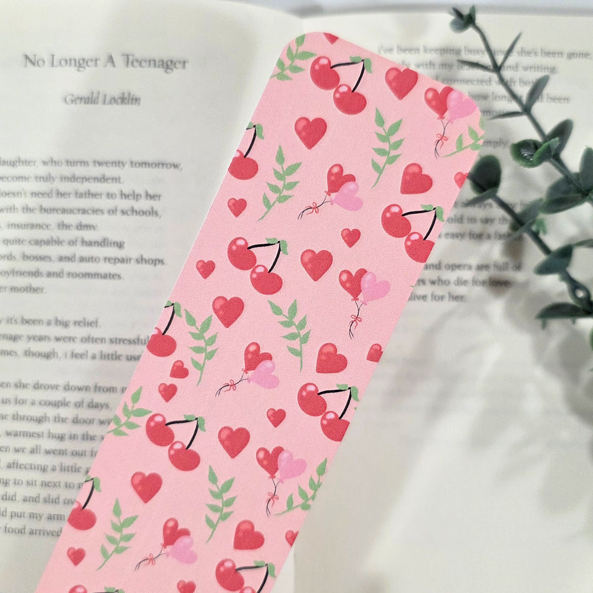 Pink Bookmark with red heart and cherry design on a book