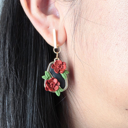 Floral earrings worn by a person with dark hair.