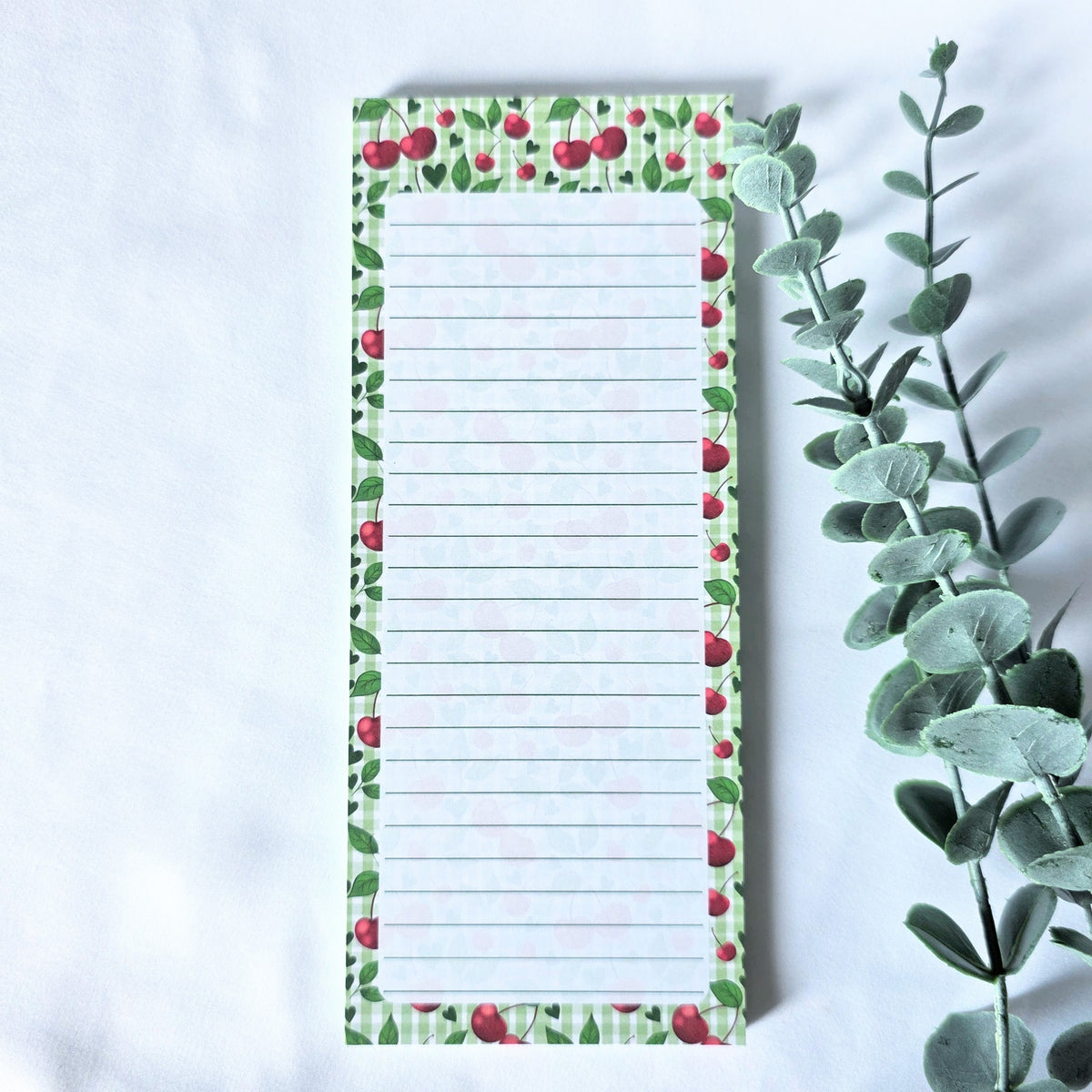 Notepad with cherry and leaf pattern on a white background