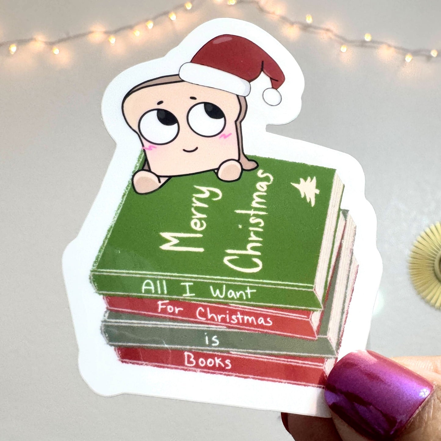 3 inch vinyl, water resistant sticker of a stack of books that say "all I want for Christmas is books"