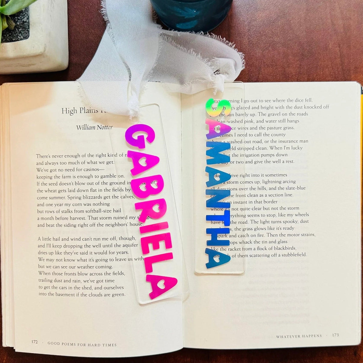 Open book with personalized name bookmarks on a wooden surface