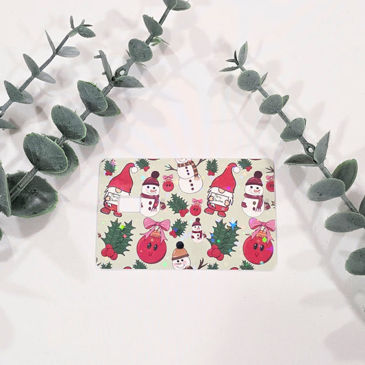 card skin sticker with Christmas-themed design featuring gnomes, snowmen, and holly leaves on a white background.