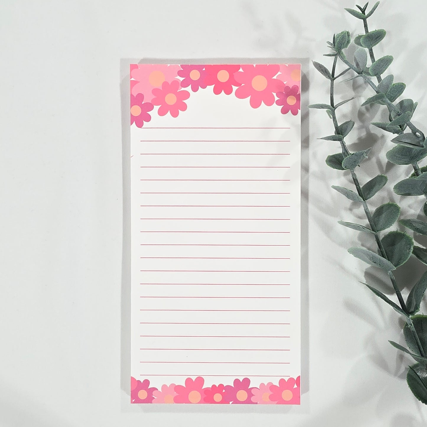 Notepad with floral border on a light background