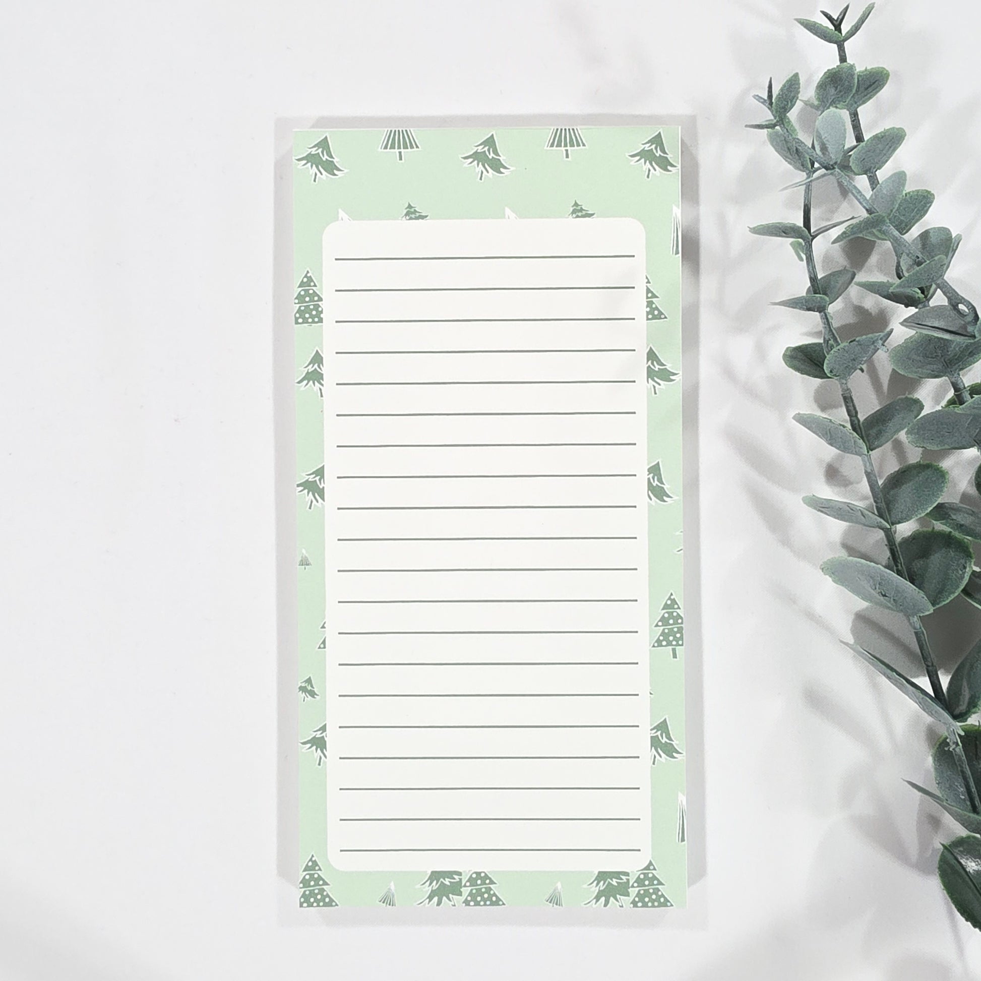 Notepad with green christmas tree border on a white background