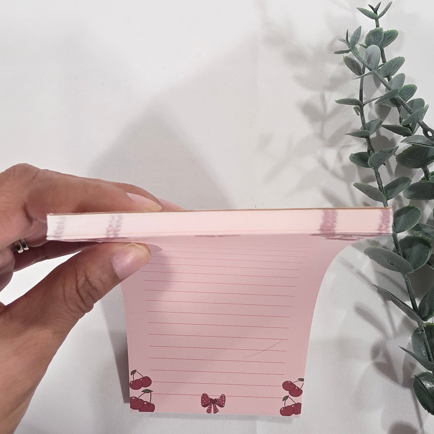 Bloc de notas con lazos rojos y cerezas