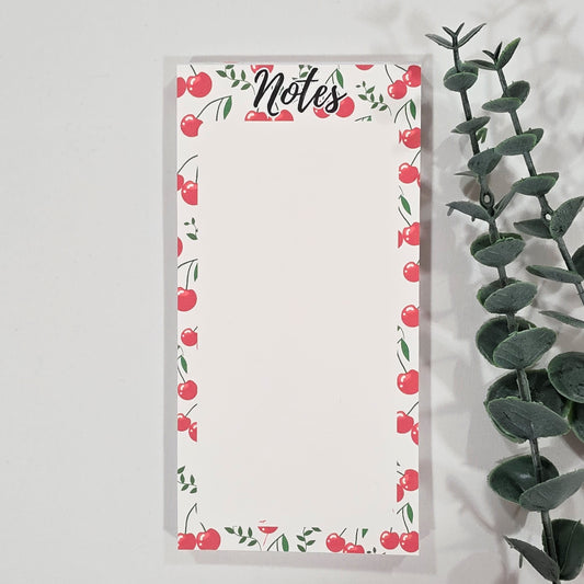 Notepad with cherry and leaf design on a white background