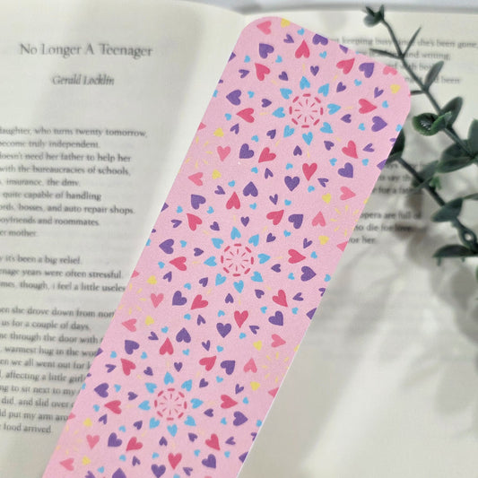 Pink bookmark with heart pattern on an open book