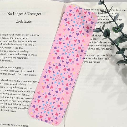 Pink bookmark with heart pattern on a book page