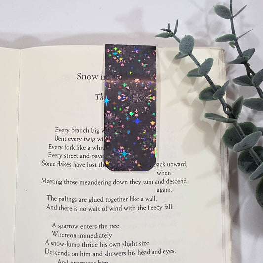 Heart snowflakes patterned, black bookmark on an open book with a white background