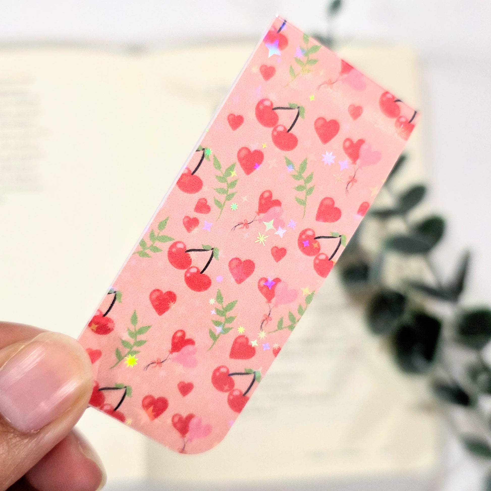 Bookmark with cherry and heart pattern held by a hand