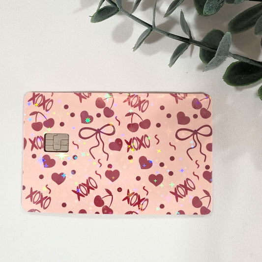 Pink card with heart and bow designs on a light background