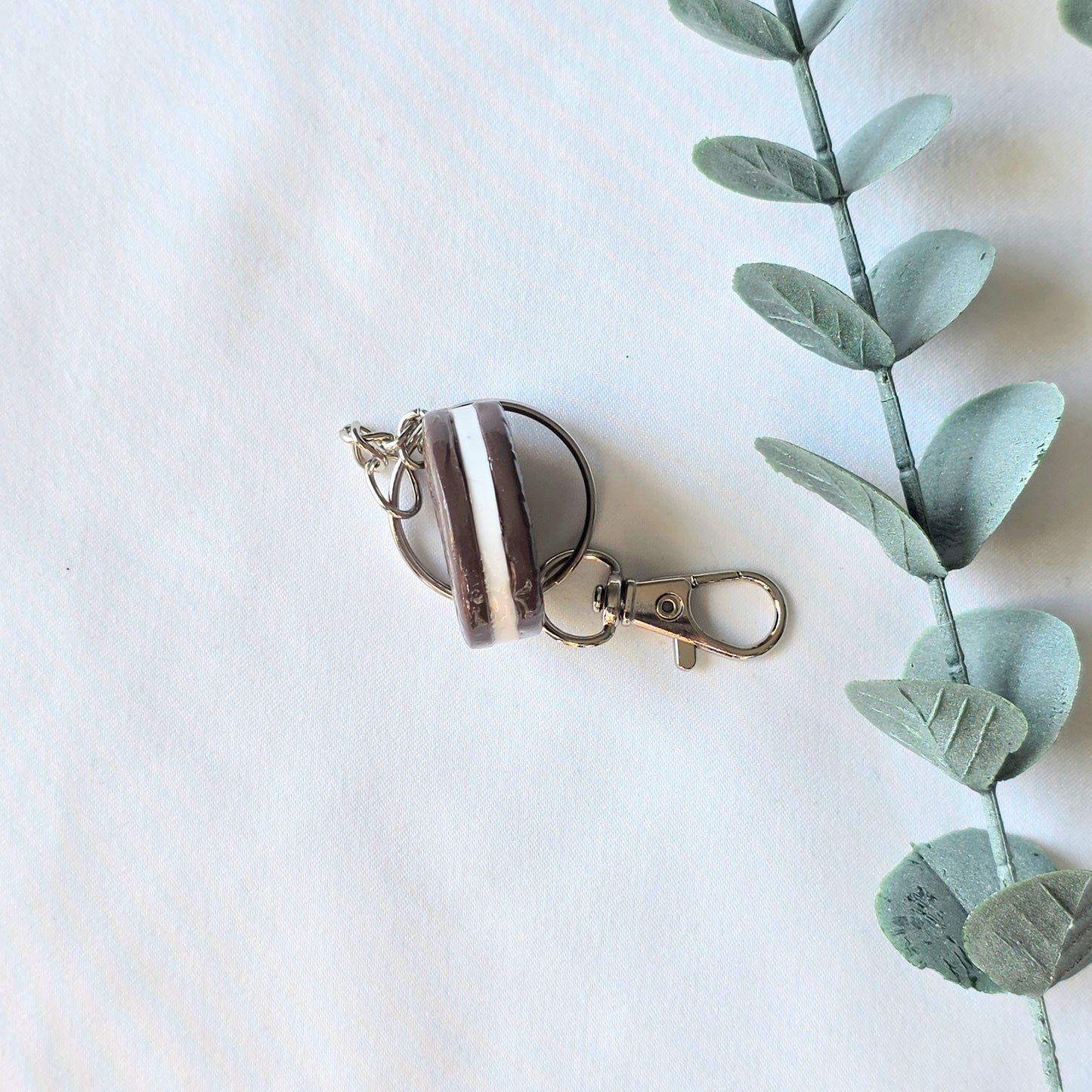 Cookie keychain on a white background with a green leafy branch.