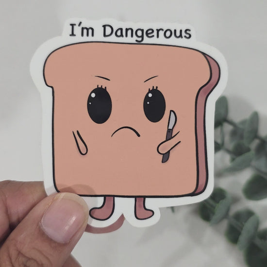 Funny toast sticker with angry face holding a small knife and text that says “I’m Dangerous”