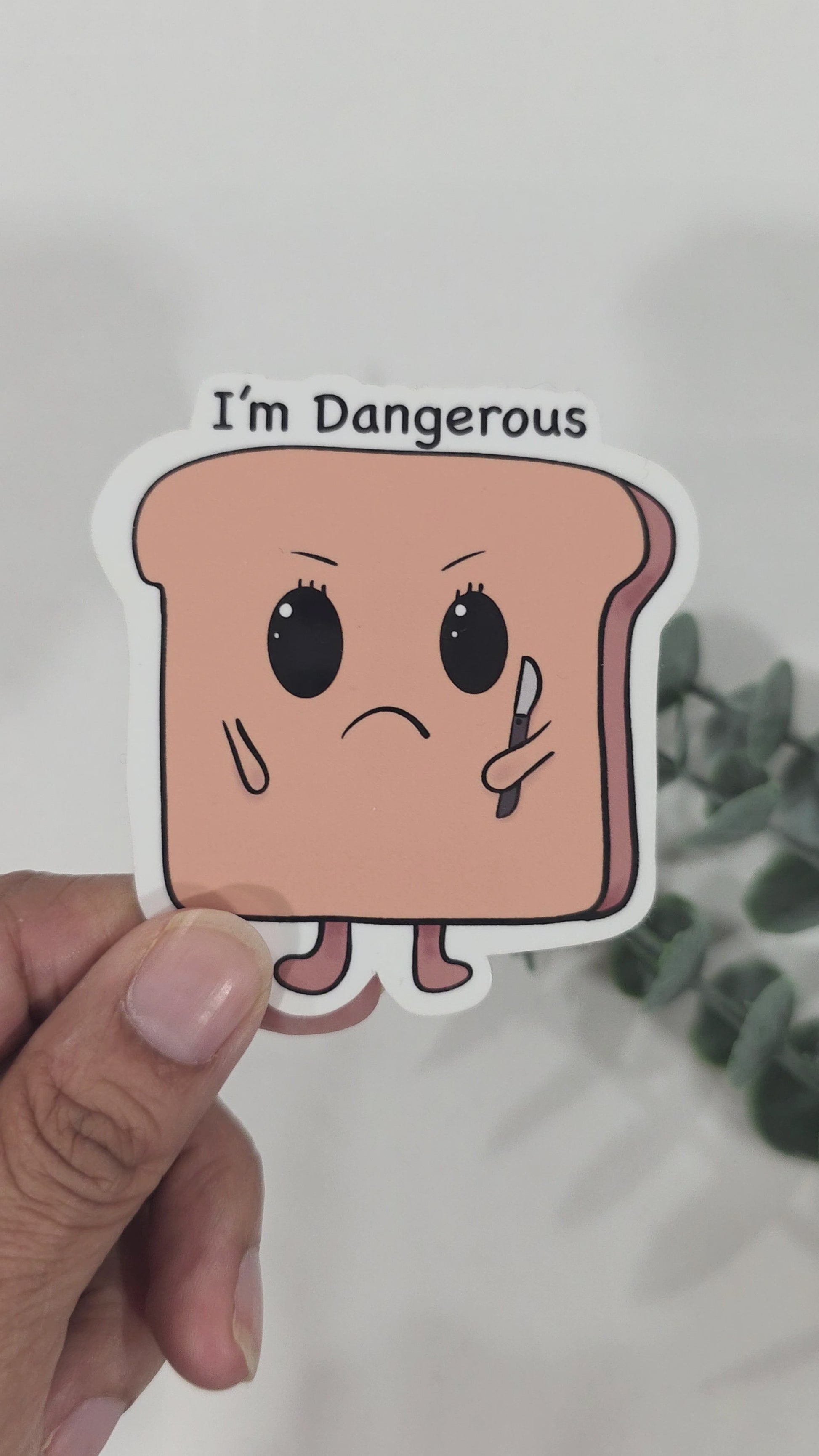 Funny toast sticker with angry face holding a small knife and text that says “I’m Dangerous”
